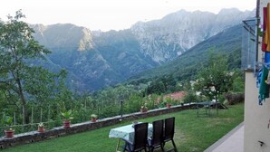 Eine Terrasse mit Tisch und Stühlen mit Blick auf eine Berglandschaft.