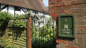A traditional cottage with a white exterior and a brick wall. - Just So Cottage (Buckingham)