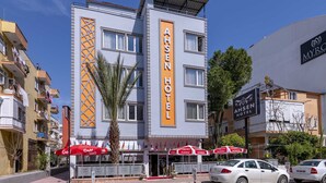 Un hôtel moderne, reconnaissable à son enseigne bien visible, doté de nombreux balcons et agrémenté de parasols sur sa terrasse extérieure.
