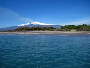 Uma praia com uma montanha ao fundo.