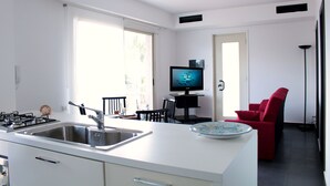 A modern kitchen with a sink, stove, and dining area.