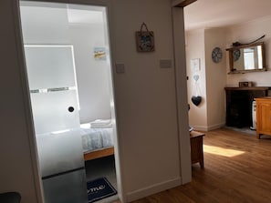 Una habitación con una cama, una mesita, una chimenea y un espejo en la pared.