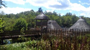 A traditional thatched-roof structure with a wooden fence in front. - Family Retreat With Panoramic Lake View And Large Front And Back Gardens (Newmarket-On-Fergus)