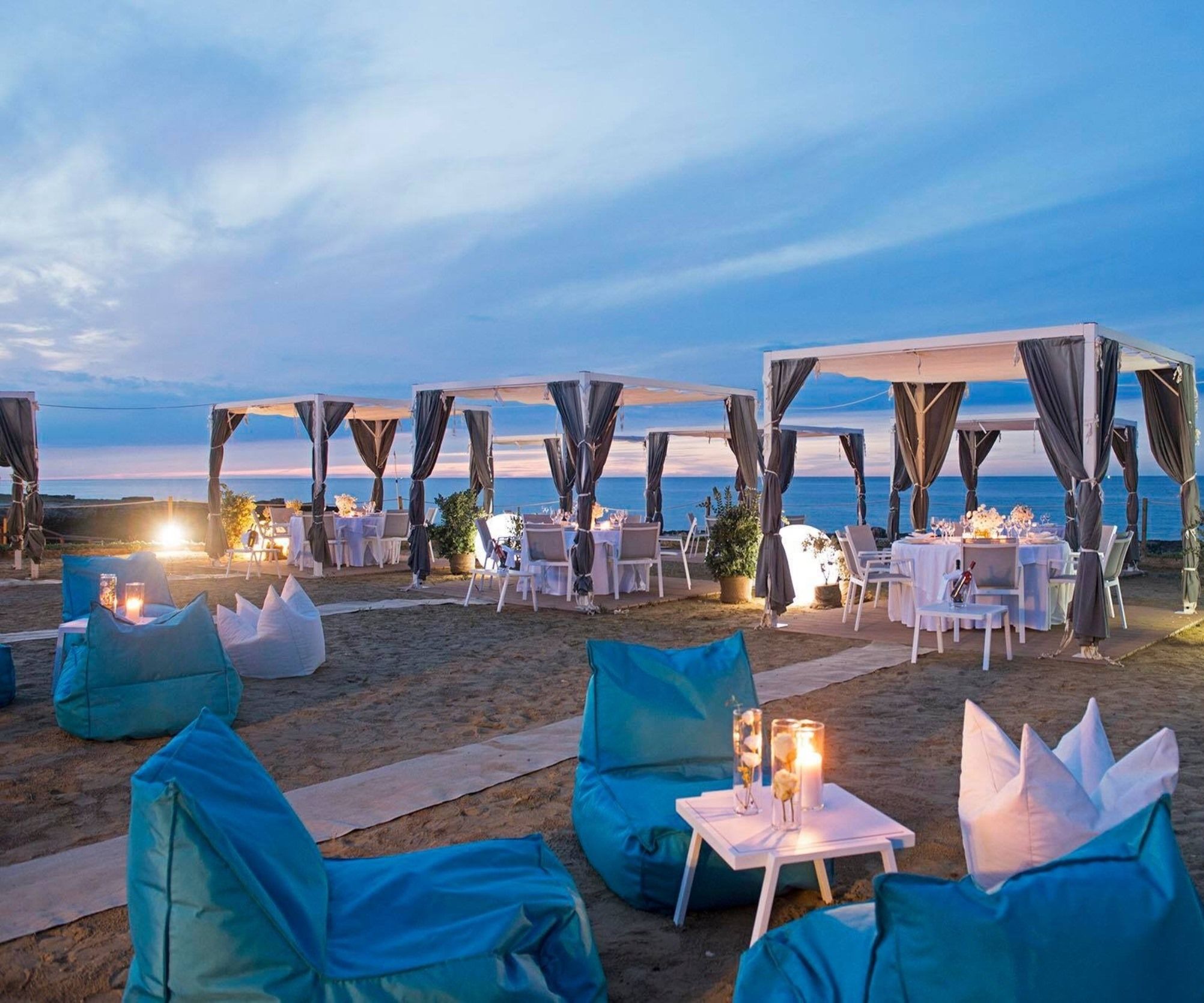 Un espace de restauration en plein air, avec des tables et des chaises, aménagé sur une plage.
