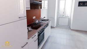 A modern kitchen with white cabinets, a wooden countertop, a built-in oven, and a window above the sink.