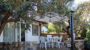 An outdoor patio with stone walls, a table with chairs, and a lamp post. - Apartment/ flat - Monte argentario (Monte Argentario)
