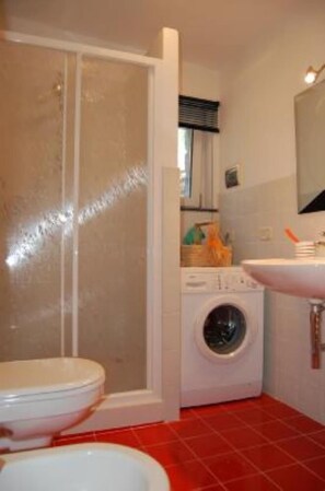 Un baño con inodoro, lavadora y lavabo.