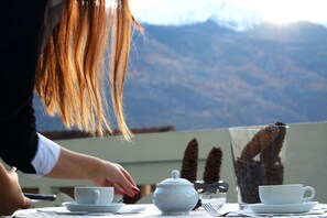 A table set for tea with a view of mountains in the background. - Hotel Miramonti (Saint-Vincent)