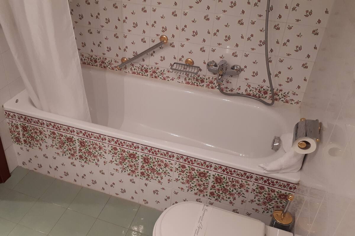 A bathroom with a bathtub, toilet, and shower.
