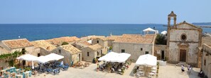 Un pueblo costero con terrazas al aire libre e iglesia histórica.