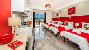 Une chambre d’hôtel dotée d’un coin cuisine, d’une table à manger et offrant une vue sur l’extérieur.