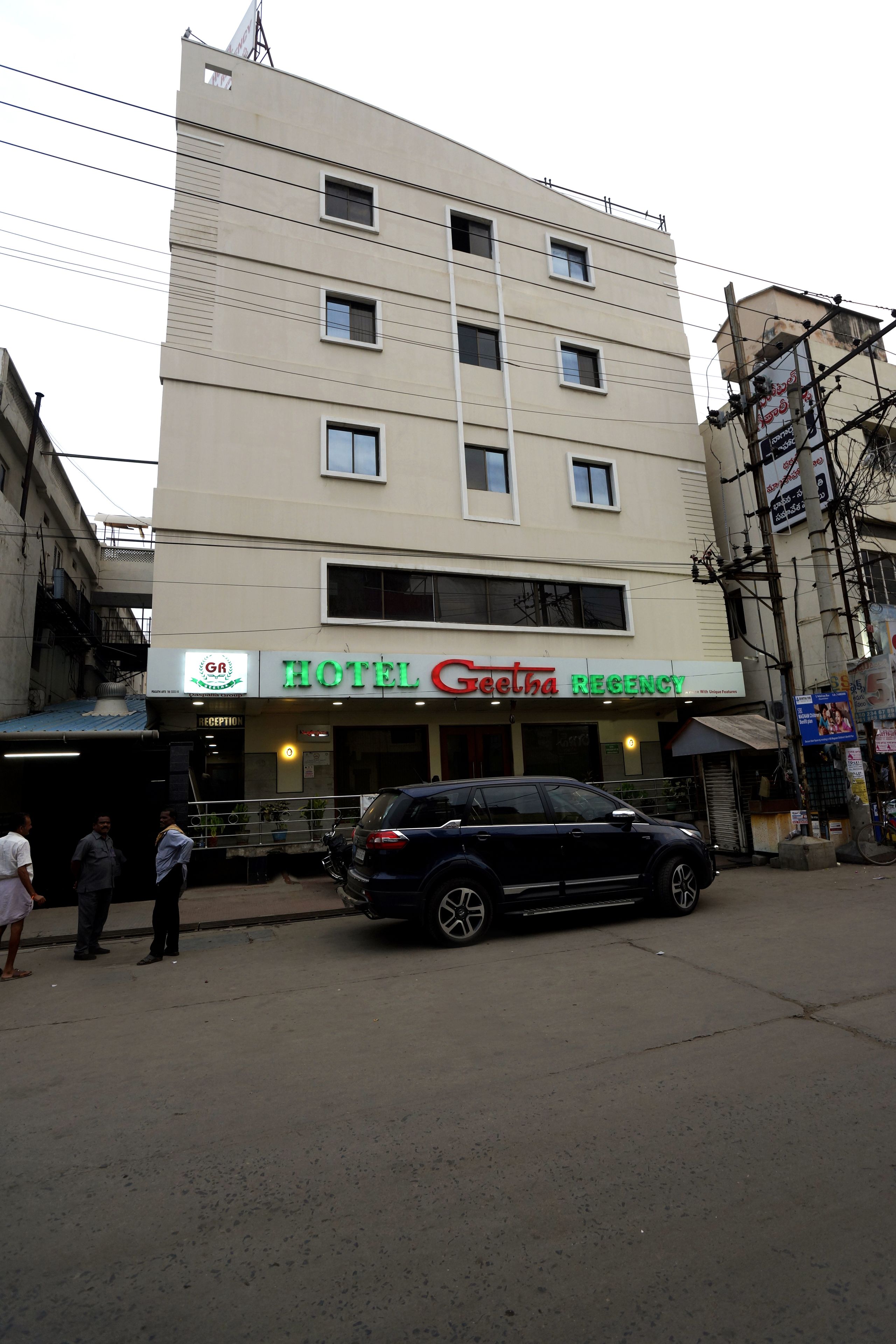 A multi-story building with a sign for 'Hotel Geetha Regency' on the ground floor.
