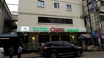 A multi-story building with a sign for 'Hotel Geetha Regency' on the ground floor.