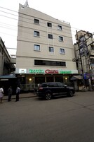 A multi-story building with a sign for 'Hotel Geetha Regency' on the ground floor.