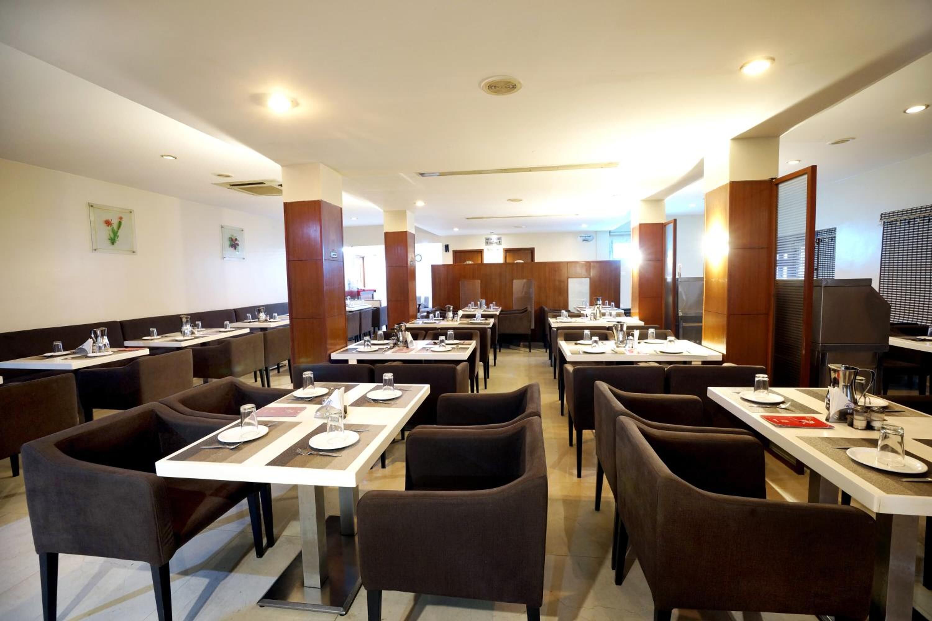 Un restaurante con varias mesas y cabinas, equipado con vajilla y sillas.
