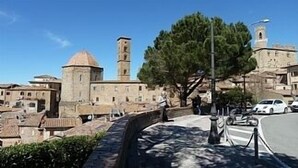 A historic town with stone buildings, a prominent tower, and a paved walkway. - Apartment in Beautifully Restored Medieval Tuscan Village, 7klm from Volterra (Pisa)