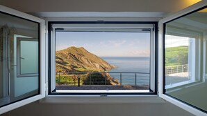 A room with a large window offering a coastal view, including a mountain and the sea. - Perched on a Hill Overlooking the Cretan Sea (Rethymno)