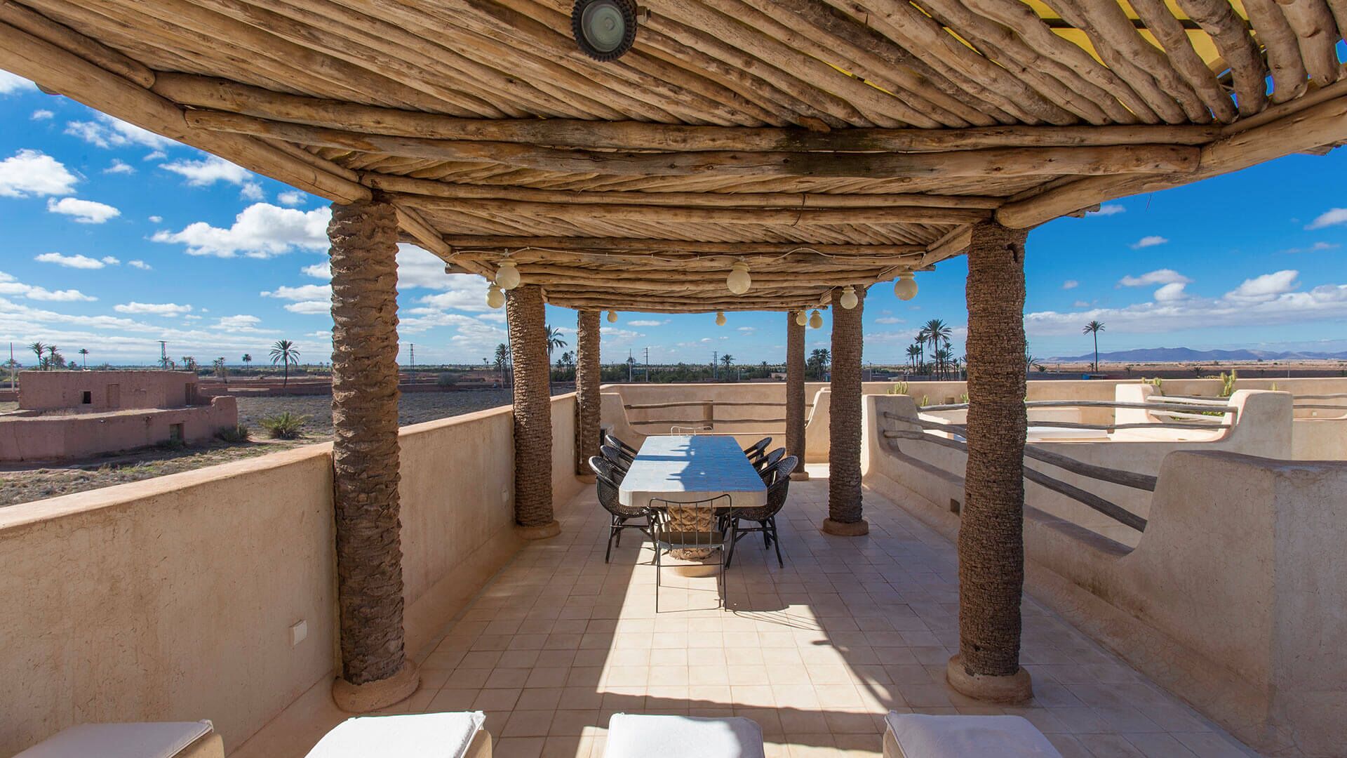 Eine Terrasse im Freien mit einer Holzhütte, einem Esstisch und Stühlen.