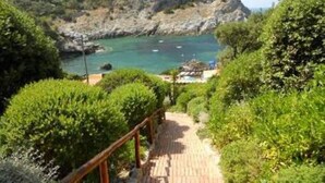 Camino costero que lleva a un acantilado rocoso con una vista despejada del mar.