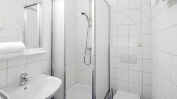 A modern bathroom with a glass-enclosed shower, a sink, and a toilet.