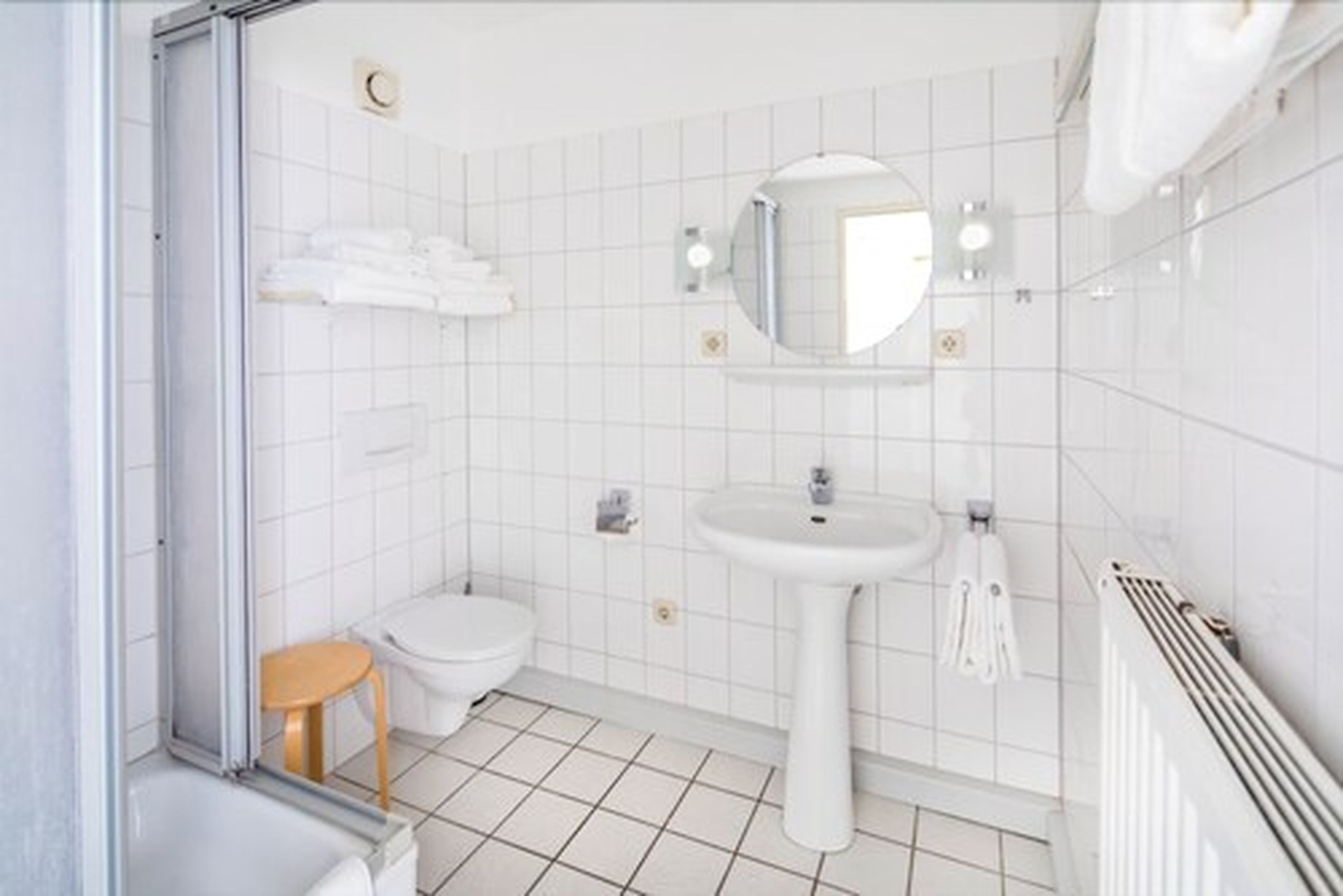 A modern bathroom with a shower, toilet, and sink.