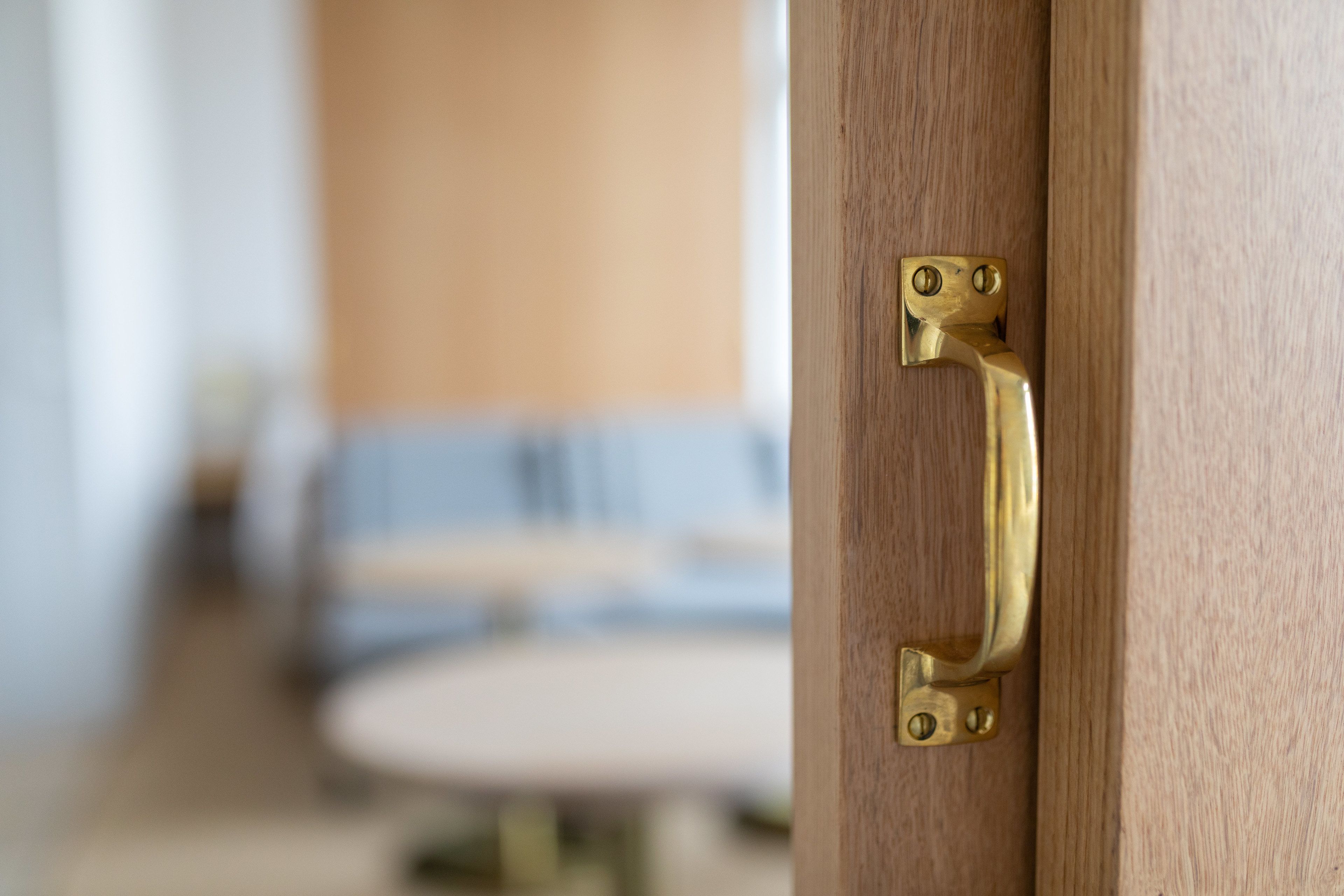 Une poignée de porte en laiton sur une porte en bois.