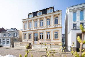 A multi-story building with a classic architectural style, featuring a prominent entrance and a balcony.