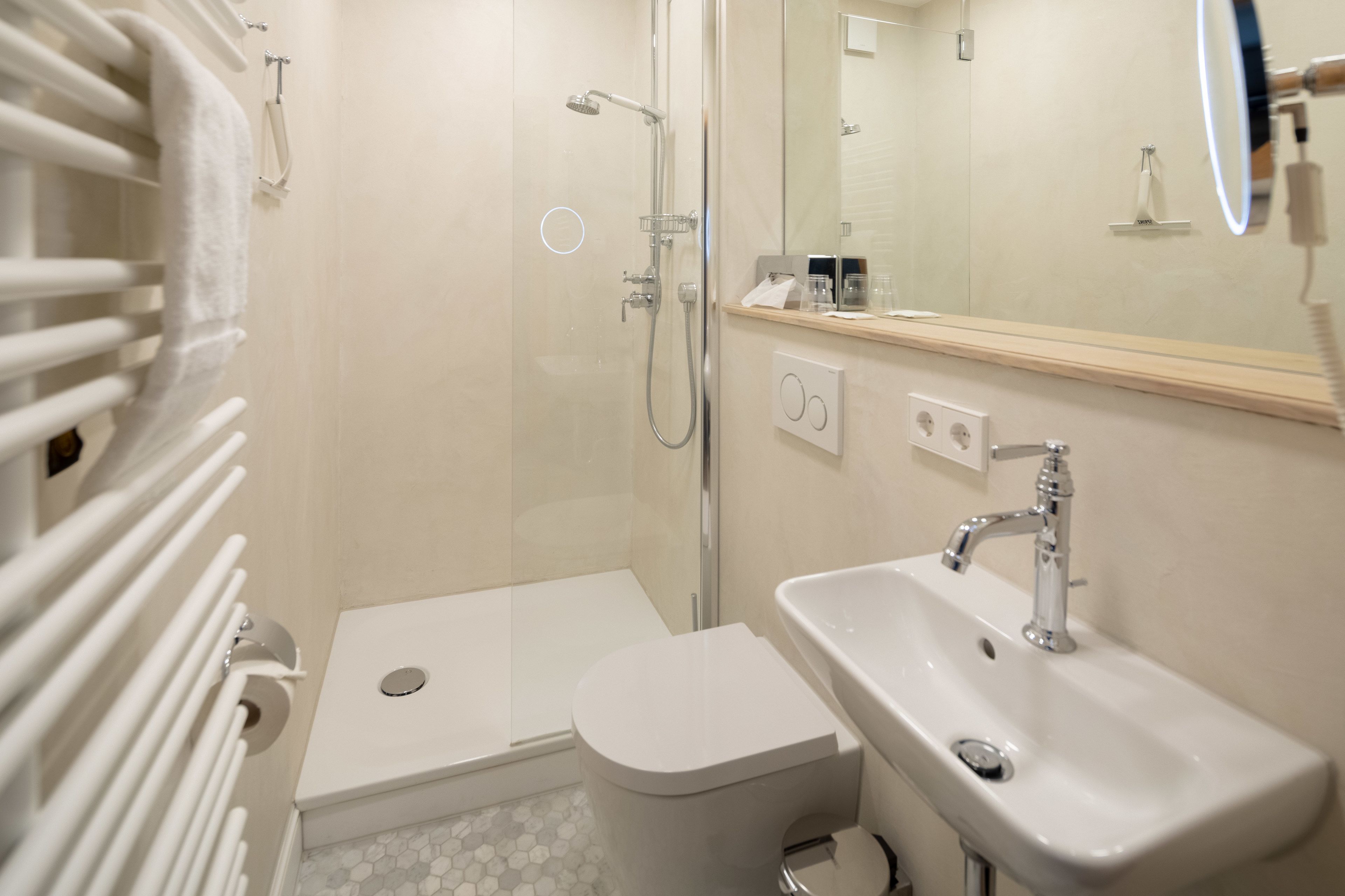 Une salle de bain équipée d’une douche, de toilettes, d’un lavabo et d’un miroir.