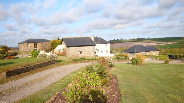 A stone building with a gravel driveway and a well-maintained lawn.