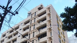 A multi-story building with a beige facade, multiple balconies, and air conditioning units. - Jaya Residency (Kakinada)