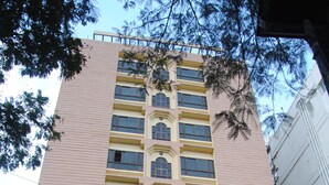 A multi-story building with a sign indicating a conference hall and a restaurant. - Jaya Residency (Kakinada)