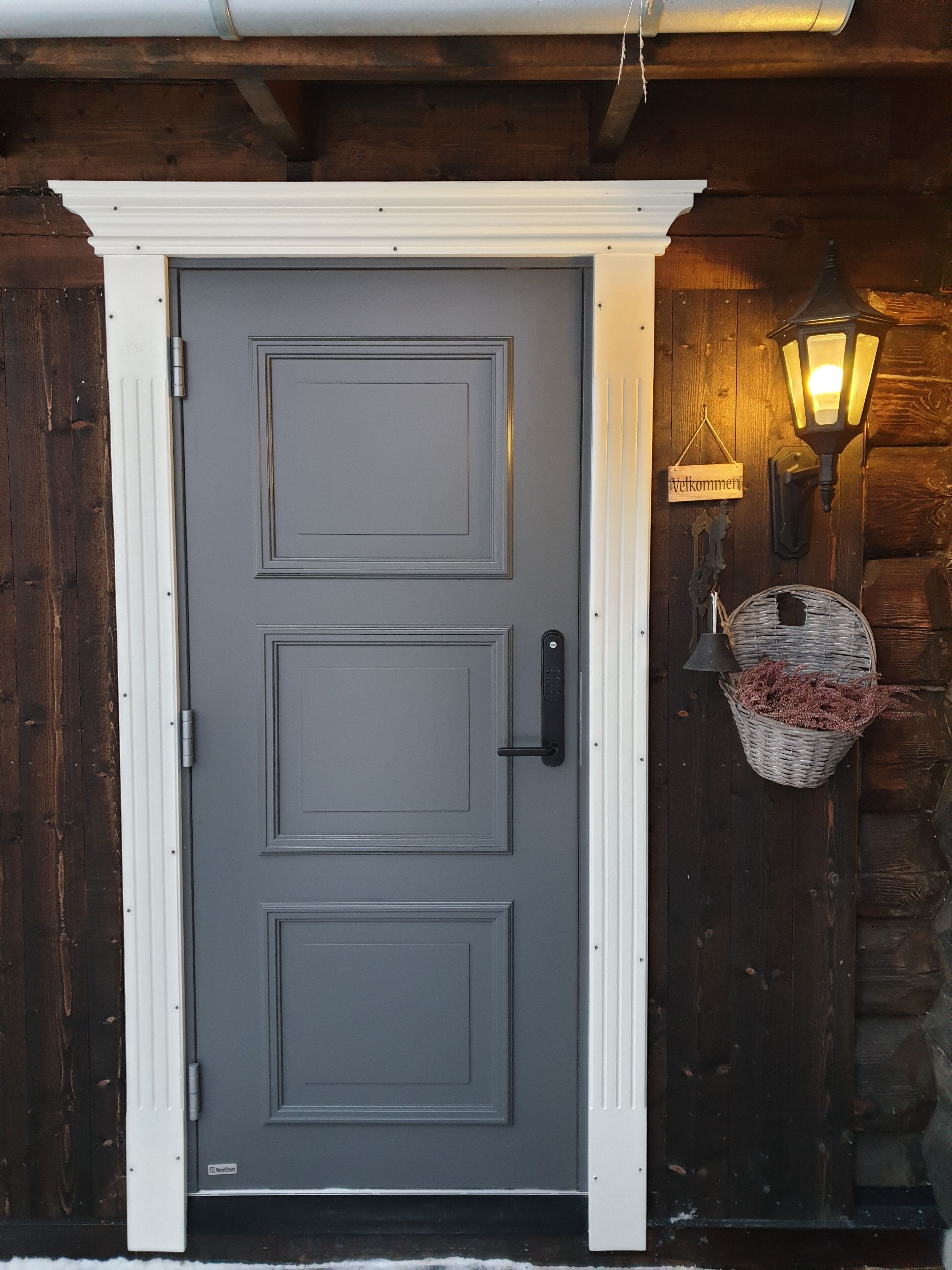 A grey door with a white frame, a black handle, and a keypad lock.