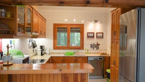Eine Küche mit Holzschränken, einem Edelstahlkühlschrank und einer Holzeinsel.