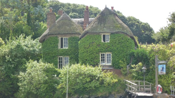 A house with ivy-covered walls, a thatched roof, and a small dock. - Romantic Retreat (Penryn)