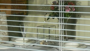 A dining table with plates, a glass, and a vase of flowers. - Romantic Retreat (Penryn)