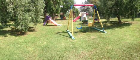 A playground with a swing set and slides.