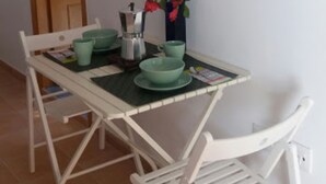 Un comedor con una mesa, sillas, un televisor de pantalla plana montado en la pared y una puerta al fondo.