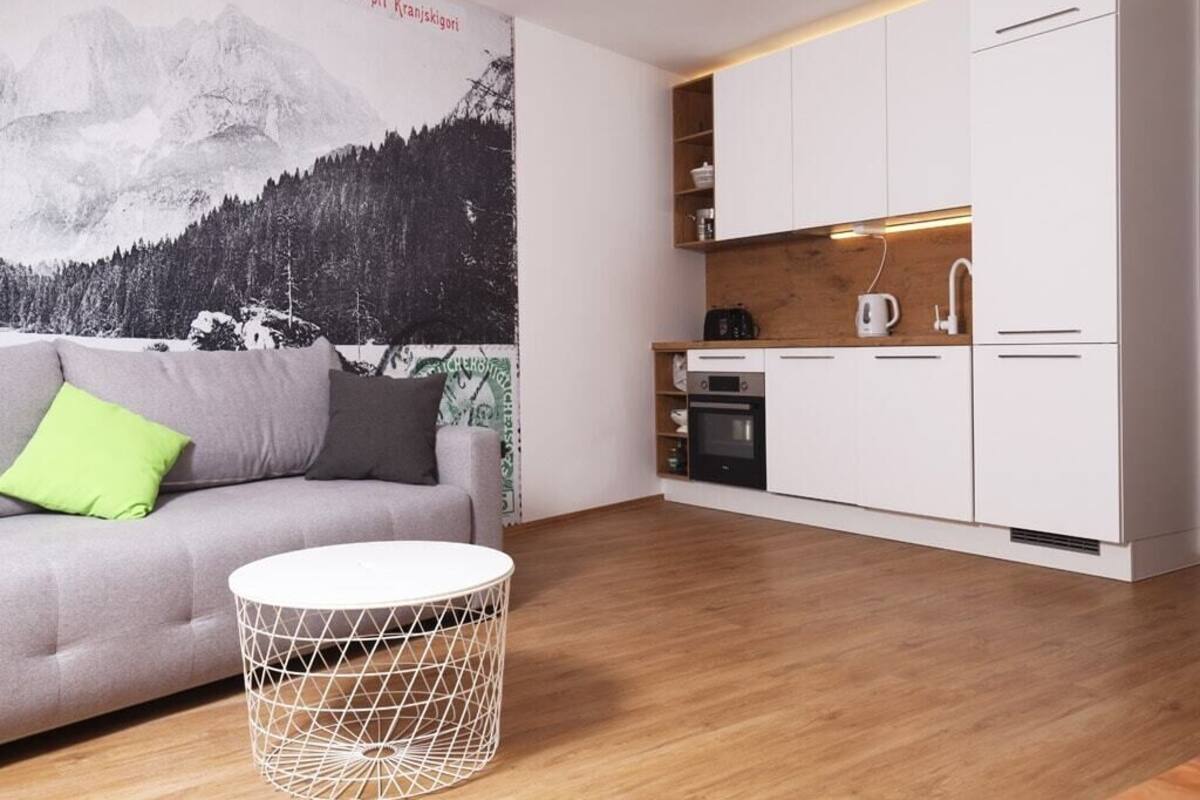 A modern kitchen with white cabinets, a wooden countertop, and a built-in oven.