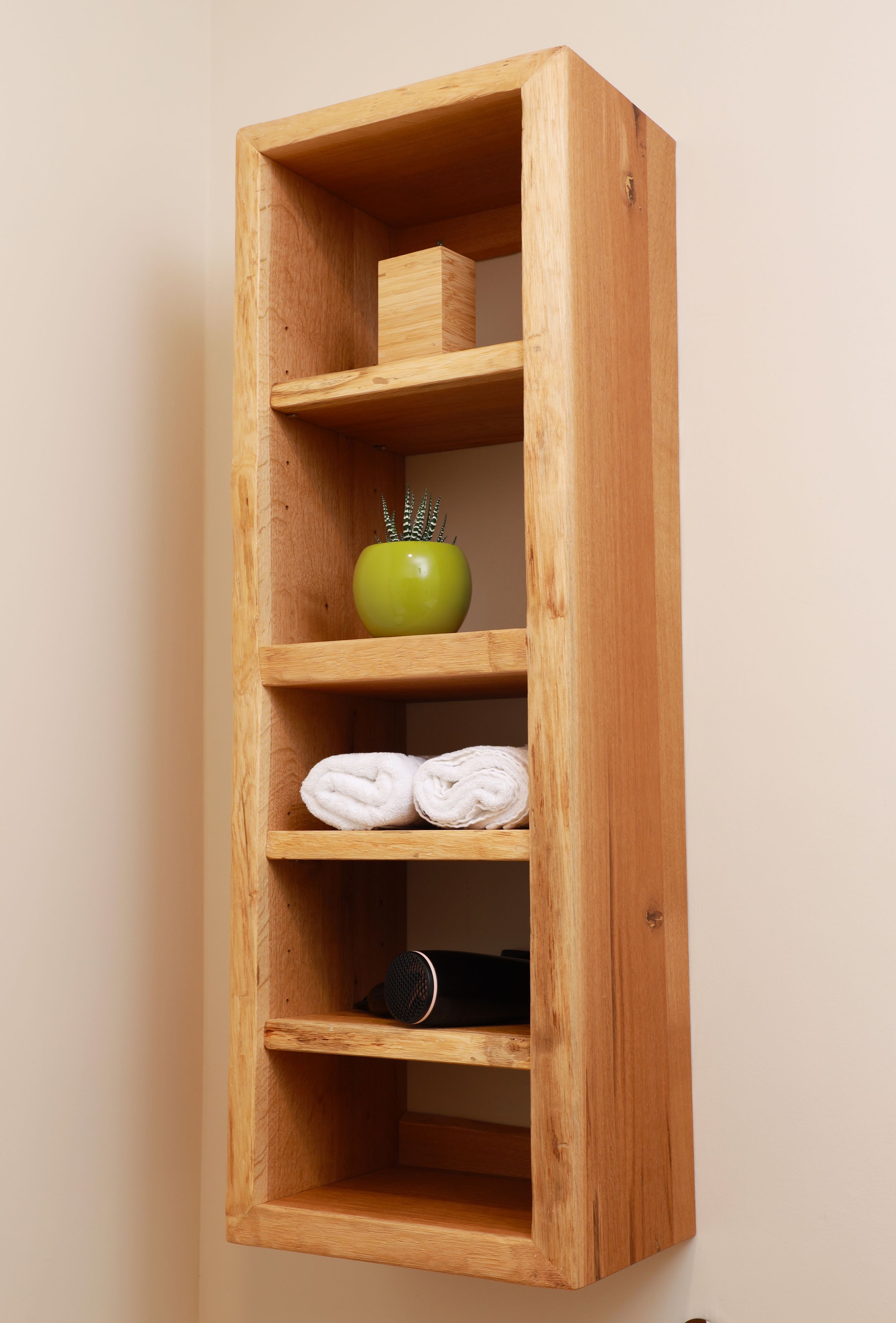 A wooden shelf unit with three shelves, each holding different items.