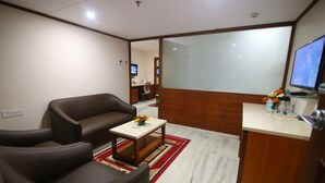 A modern living room with a sofa, a coffee table, and a TV. - Daspalla Executive Court (Visakhapatnam)