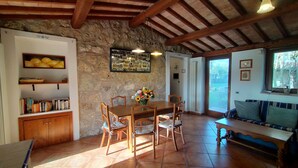A rustic dining area with a wooden table and chairs, surrounded by stone walls and wooden beams. - Casale Eredità cottage countryside Tiber Valley  private  pool 70 km North Rome (Orte)