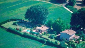 An aerial view of a property with a swimming pool, multiple buildings, and surrounding green fields. - Casale Eredità cottage countryside Tiber Valley  private  pool 70 km North Rome (Orte)