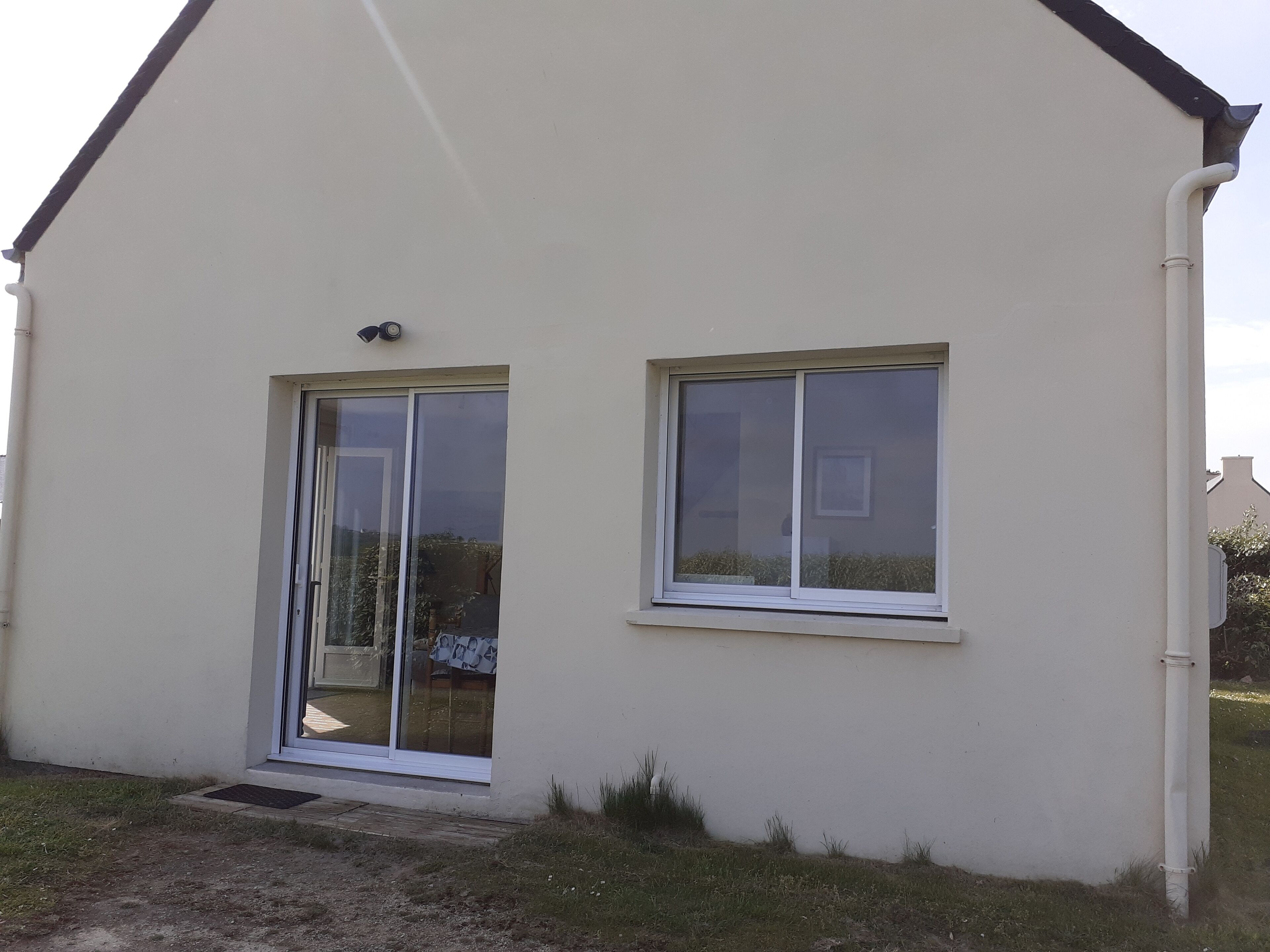 A single-story building with a flat roof, a sliding glass door, and a small window.