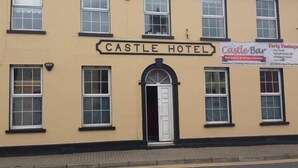 A building labeled "CASTLE HOTEL" with a sign for "Castle Bar" advertising party packages. - Castle Inn (Strabane)