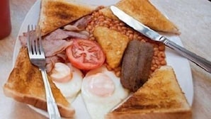 A plate of breakfast with toast, eggs, bacon, beans, and a tomato. - Castle Inn (Strabane)