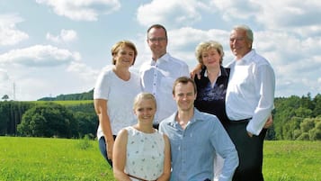 A group of people posing in a grassy field with a clear sky.