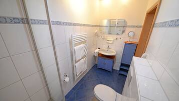 A bathroom with a toilet, sink, and mirror.