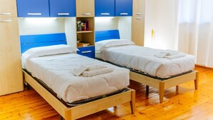 A room with two single beds, wooden flooring, and blue and white furniture. - Welc-om Green Cottage (Teolo)