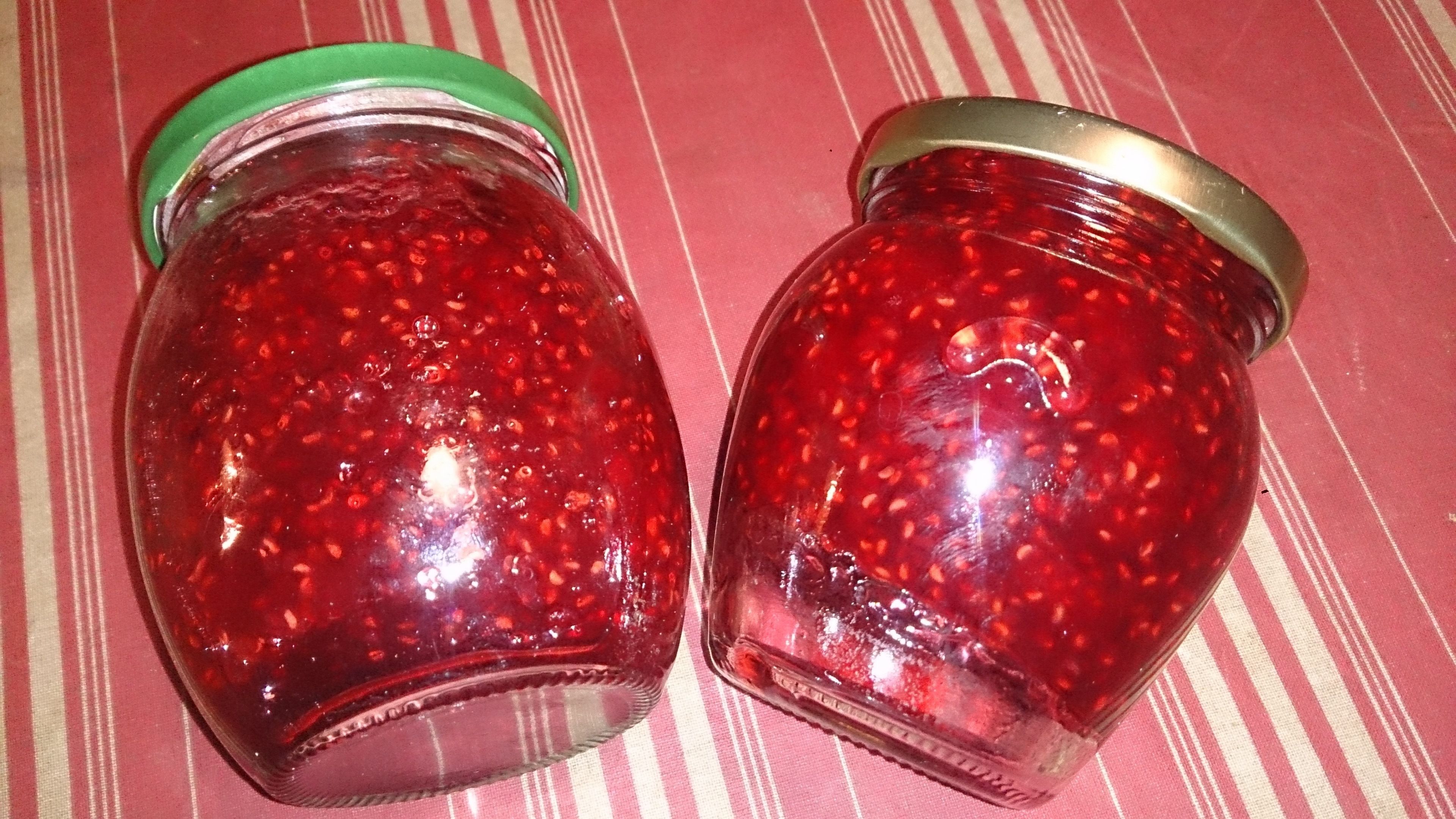 Due barattoli di vetro con un contenuto rosso su una superficie rivestita a righe.