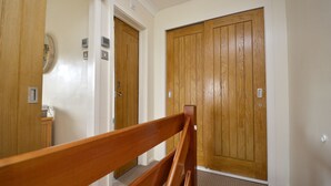 A hallway with wooden doors and a wooden handrail.